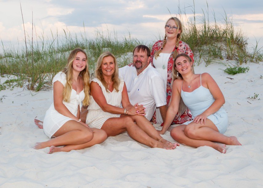 Katie with her parents and sisters together on the beach