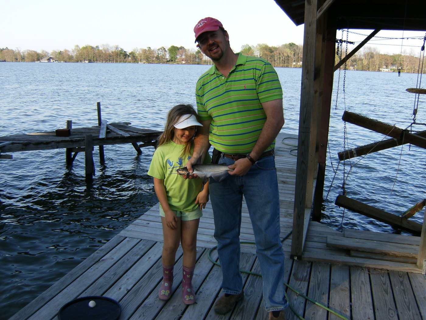 Young Katie and her father holding a fish beside the lake