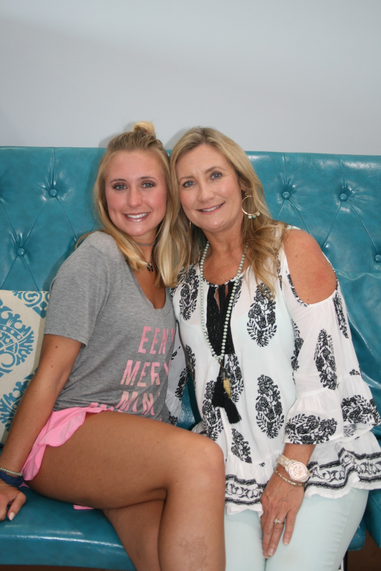 Katie and her mother Kim sitting together on a turquoise seat