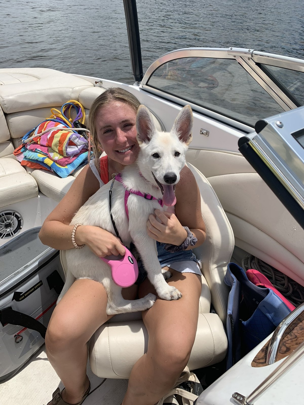 Katie holding Remi as a puppy on a boat