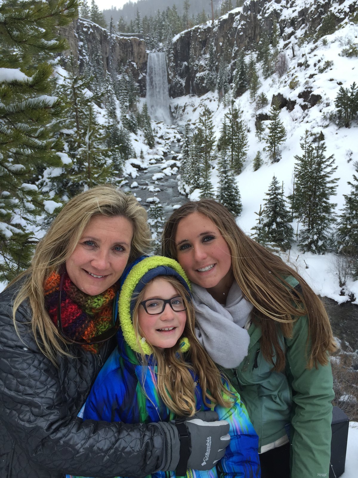 Katie with family in front of a snowy waterfall